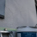 Micro fissure crépi extérieur sur façade, près d’un angle de fenêtre
