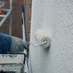 Rouleau pour facade à fibres longues appliqué sur mur en crépi extérieur